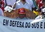 Pessoa segurando cartaz, aparecendo escrito "em defesa do SUS"