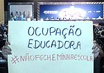 Auditório em mesa da 15ª Conferência Nacional de Saúde,  com cartaz escrito "Ocupação educadora"