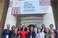 Equipe de profissionais da Fiocruz se reúne para foto em frente a entrada da "The Global Health Network Conference" na  Cidade do Cabo
