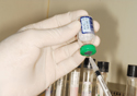 Foto de profissional de saúde enchendo uma seringa com vacina