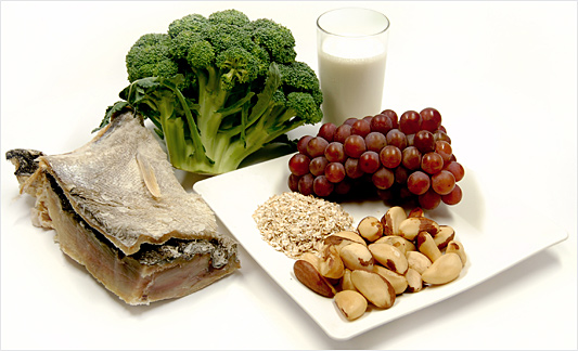 Alimentos como bacalhau e brócolis, dispostos numa mesa