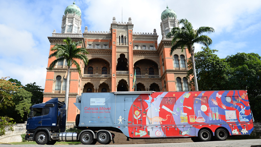 Foto do caminhão do Ciência Móvel em frente ao Castelo Fiocruz