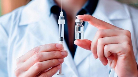 Médico com uma seringa de vacina na mão