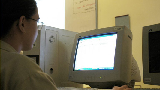 Foto de uma menina usando o computador para estudar