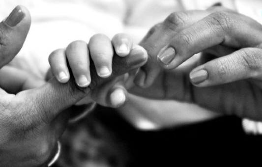 Mãe segurando a mão de um bebê