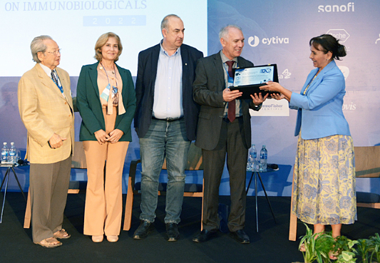 Diretor de Bio-Manguinhos, Mauricio Zuma, e o assessor científico sênior e coordenador do simpósio, Akira Homma, recebendo a placa