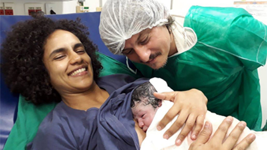 Mulher com bebê recém-nascido e o médico