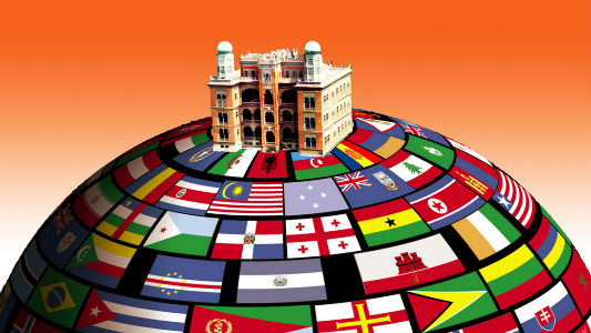 Arte com castelo da Fiocruz sobre um globo forrado com bandeiras de vários países