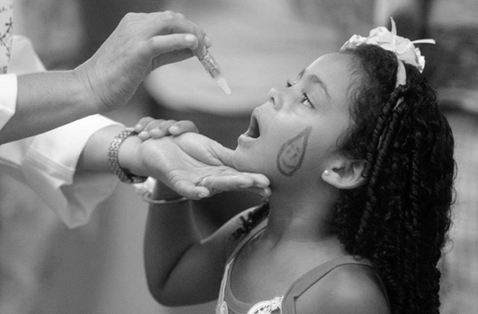 Foto de menina tomando vacina