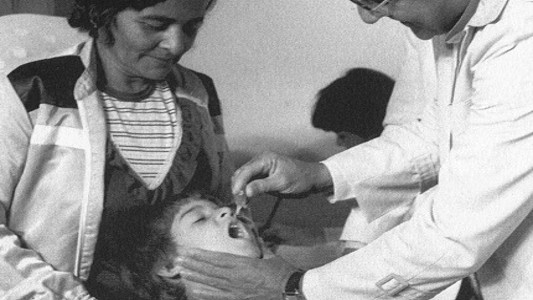 Criança tomando vacina em gotas