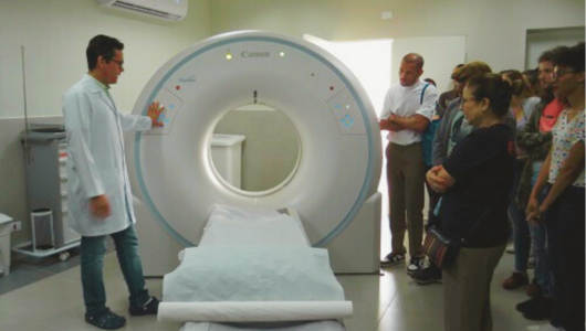 Universitários observam médico demonstrar funcionamento de equipamento em hospital