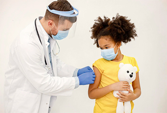 Médico aplicando vacina no braço de uma menina