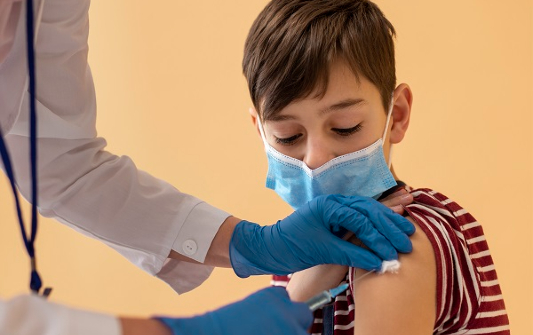 Menino tomando vacina contra Covid-19