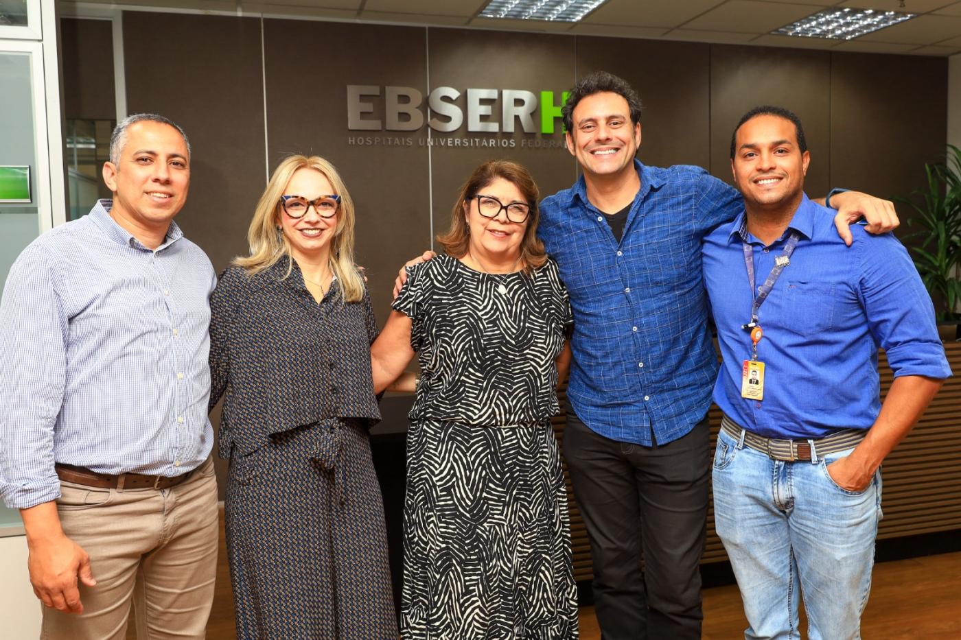 Grupo de pessoas em pé posando para foto