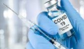 Vacina contra Covid-19 e uma seringa na mão de um médico
