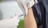 Foto de aplicação de vacina no braço por profissional de saúde