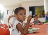 Criança comendo no refeitório da escola