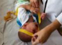 Foto de bebê tendo a cabeça medida com fita métrica