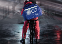 Capa da revista mostra um entregador de comida em uma bicicleta na rua em um dia de chuva forte