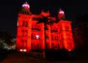 Foto noturna do castelo da Fiocruz iluminado com luz vermelha