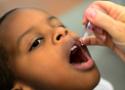 Criança tomando vacina em gotas