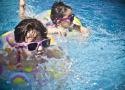 Crianças com óculos escuros mergulhando na piscina