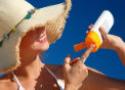 Mulher com chapéu usando protetor solar