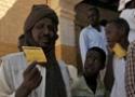 Moradores da região de Darfur com cartão de vacinação em mãos