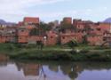 Casas sem pintura às margens de um rio; favela