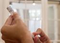 Enfermeiro aplicando a seringa na vacina