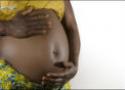 Recorte de mulher negra grávida com as mãos envolvendo a barriga