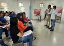 Pessoas assistem à palestra sobre dengue em sala de aula