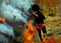 Criança correndo do lado do fogo em um gramado
