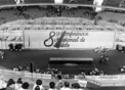 Foto em preto e branco mostra estádio com fundo da Oitava Conferência