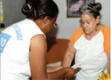 Mulher agente comunitária de saúde cuidando de uma mulher idosa