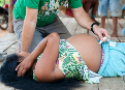 Mulher indígena deitada no chão sendo examinada por um médico