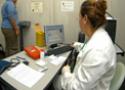 Mulher sobre uma balança diante de uma médica durante atendimento em consultório