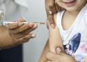 Menina tomando vacina no braço