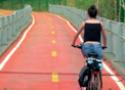 Garota andando de bicicleta, numa ciclovia